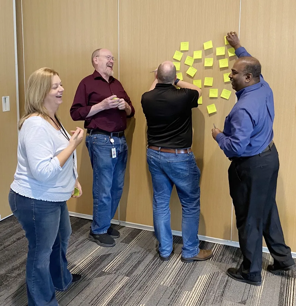 Professionals collaborating with sticky notes during a corporate workshop